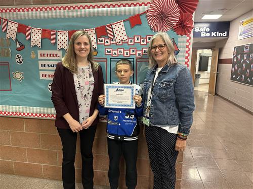 McKinley's Stairclimber for October, Isaiah Colon, poses with his certificate with school staff.